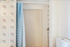 a bathroom with a toilet and a shower curtain at Karai traditional house in Astypalaia Town +16 photos