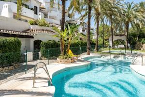 basen przed budynkiem z palmami w obiekcie Golden Beach Elviria w Marbelli
