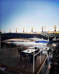 a table and chairs on a boat with a bridge at Péniche de charme au pont Alexandre III in Paris