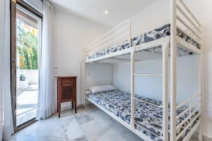 sypialnia z dwoma łóżkami piętrowymi i oknem w obiekcie Golden Beach Elviria w Marbelli +15 zdjęć