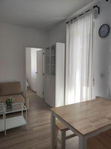 a living room with a table and a couch at Casa Dina II. in Carballino