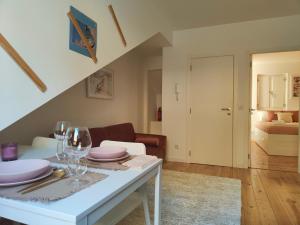 uma sala de estar com uma mesa com copos de vinho em Rose Essence Aparment - Exceptional balcony em Coimbra