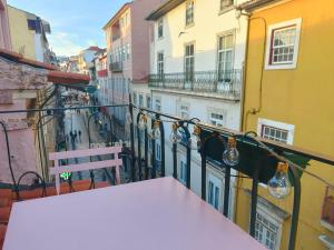 uma varanda com uma mesa e um banco e edifícios em Rose Essence Aparment - Exceptional balcony em Coimbra