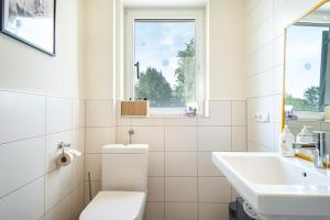 bagno bianco con servizi igienici e lavandino di Lodge 21 a Lochau