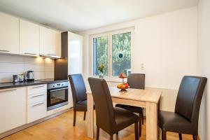 una cucina e una sala da pranzo con tavolo e sedie in legno di Lodge 21 a Lochau