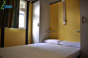 Dormitorio pequeño con cama y ventana en Camping Ampurdanes, en Roses