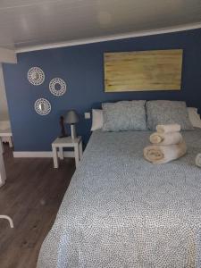 um quarto com uma cama com uma parede azul em Minha casa em Olhão
