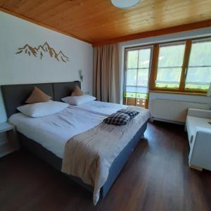 a bedroom with a large bed with mountains on the wall at Forsthaus Falkner in Sölden