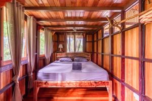 un dormitorio en una casa del árbol con una cama en ella en Paradiselodge Jungleguesthouse en Platanillo