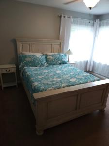 una camera da letto con un letto con un piumone blu e una finestra di The Walnut Nest a Emporia