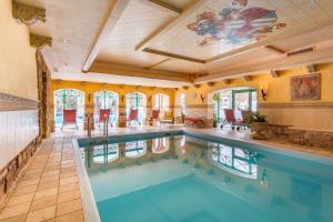 an indoor pool in a house with a large room at Berghotel Ronach in Königsleiten