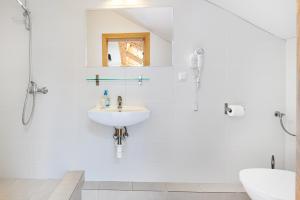een witte badkamer met een wastafel en een douche bij KOMPAS in Jastrzębia Góra