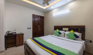 a bedroom with a large bed and a wooden cabinet at Treebo Trend MVM Residency in New Delhi