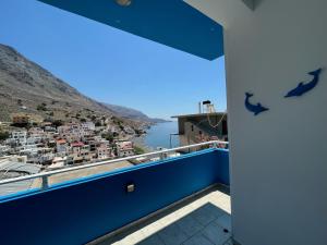 a balcony with a view of a city and water at Mediterranean Dolphin Guest House in Paránimfoi