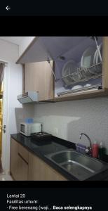 a kitchen with a sink and a microwave at Apartemen Borneo bay city in Balikpapan