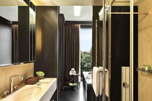 a bathroom with a tub and a sink and a window at Bulgari Hotel Milano in Milan