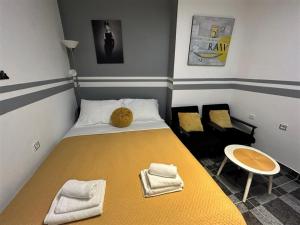 Un pequeño dormitorio con una cama amarilla y una silla en Apartment Decumana, en Krk