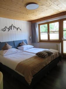 1 dormitorio con 1 cama grande en una habitación con ventanas en Forsthaus Falkner en Sölden