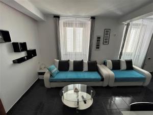 ein Wohnzimmer mit einem Sofa und einem Glastisch in der Unterkunft Apartment Decumana in Krk