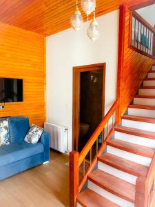 a living room with a staircase and a blue couch at Mego Suite Otel in Uzungöl