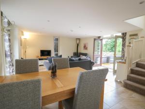 a dining room and living room with a wooden table and chairs at Gelli Barn in Llandeilo