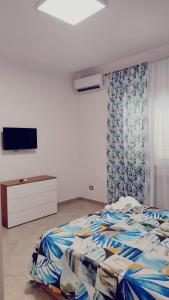 a bedroom with a bed and a tv on a wall at Lovin Puglia Vacation in Bari