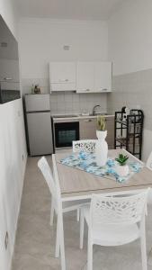 a kitchen with a table and two white chairs at Lovin Puglia Vacation in Bari