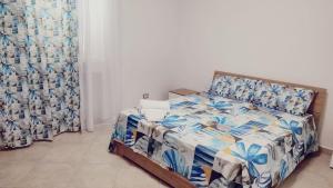a bedroom with a bed with a blue and white comforter at Lovin Puglia Vacation in Bari