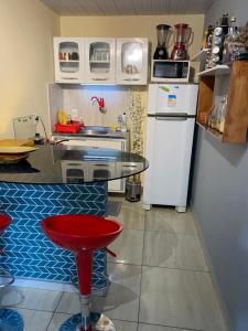 a small kitchen with a table and a refrigerator at Quarto - Nosso lar em Natal in Natal