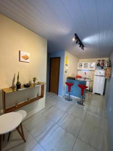a room with a kitchen with a table and a stove at Quarto - Nosso lar em Natal in Natal