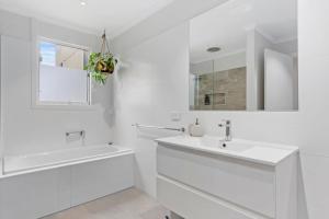 a white bathroom with a sink and a mirror at Stones Throw 26 River View Drive in Normanville +17 photos