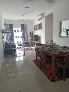 ein Esszimmer und ein Wohnzimmer mit einem Tisch und Stühlen in der Unterkunft Cikta Homestay at Southville City Savanna Suite in Kampong Tangkas