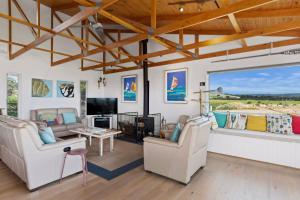 a living room with two couches and a tv at Stones Throw 26 River View Drive in Normanville