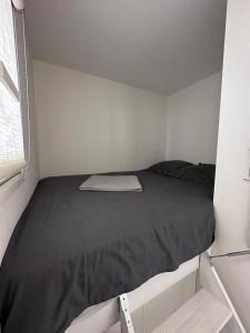 a bed in a small room with a black comforter at Studio Antibes Port Vauban. in Antibes