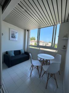 a living room with a table and chairs and a couch at Studio Antibes Port Vauban. in Antibes