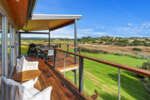 a balcony with a view of a golf course at Stones Throw 26 River View Drive in Normanville