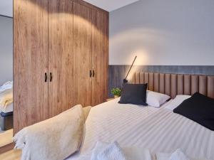 韋巴的住宿－Apartament Natura D33 Porto Łeba，一间卧室配有一张大床和木制橱柜。