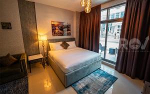 een kleine slaapkamer met een bed en een raam bij Studio with Boulevard View in Dubai