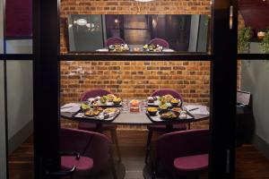 a table with plates of food on it in a restaurant at Malmaison London in London