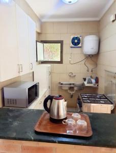 a kitchen with a tea kettle on a wooden cutting board at Chalet 3 bedrooms 2 toilets lotus north cost stand alone 3 air conditioner families are preferred available all year days & 3 blankets available in El Alamein