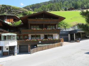 a building with a balcony with flowers on it at Forsthaus Falkner in Sölden