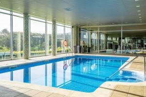 Una gran piscina en un edificio con ventanas. en Abba Comillas Hotel, en Comillas