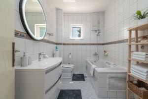 a bathroom with two sinks and a tub and a toilet at Beachfront Apartment with parking in Slatine +12 photos