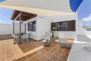 un patio con mesa y sillas en la azotea en La casa de las velas, en Playa Honda