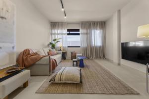 a living room with a couch and a tv at La casa de las velas in Playa Honda