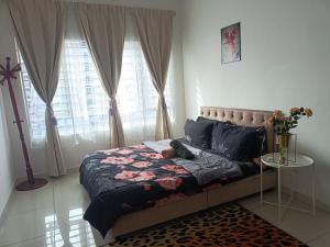 ein Schlafzimmer mit einem Bett und einem Tisch mit Blumen darauf in der Unterkunft Cikta Homestay at Southville City Savanna Suite in Kampong Tangkas