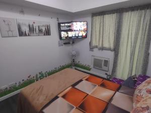 a living room with a table and a tv at Pampanga Staycation Condo Unit In San Fernando in San Fernando