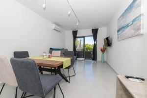 a dining room and living room with a table and chairs at Apartmani Tona in Baška Voda