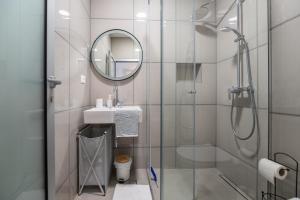 a bathroom with a shower and a sink and a mirror at Apartmani Tona in Baška Voda