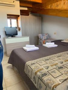 a hotel room with two beds and a tv at LE CASTELLA BEACH S.F. in Le Castella